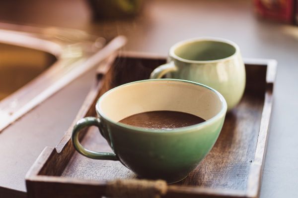 Tasse mit Kakao Zwei Tassen auf einem Holztablett