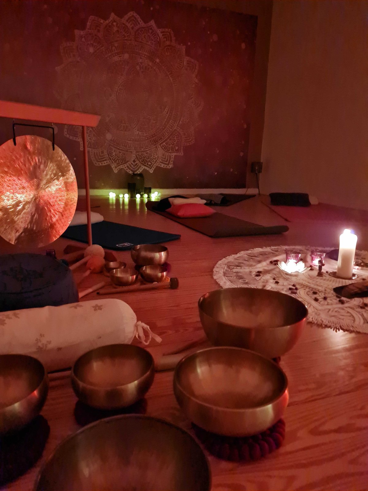 Klangschalen und Yogamatten Klangschalen, Gong, Yogamatten und ein Mandalateppich mit Kerzen